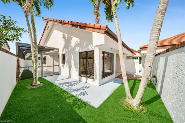 Back of property with a yard and a patio area