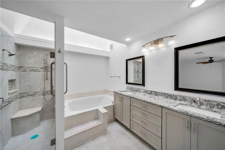 Bathroom featuring independent shower and bath, vanity, and ceiling fan