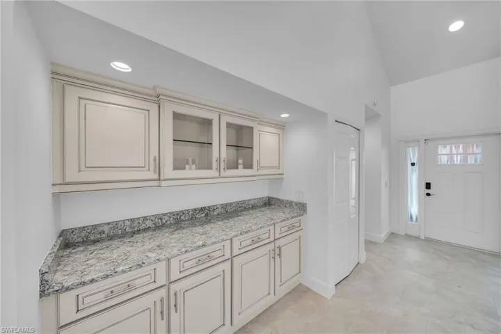 Kitchen with light stone countertops and cream cabinets