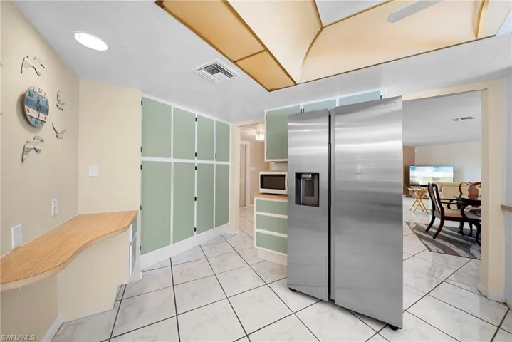 Kitchen featuring stainless steel appliances, tile floors, and plenty of cabinets