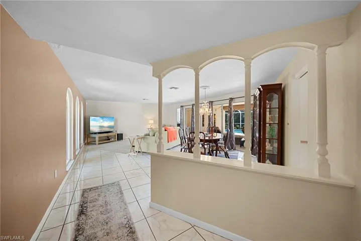 Entry with decorative columns and family room