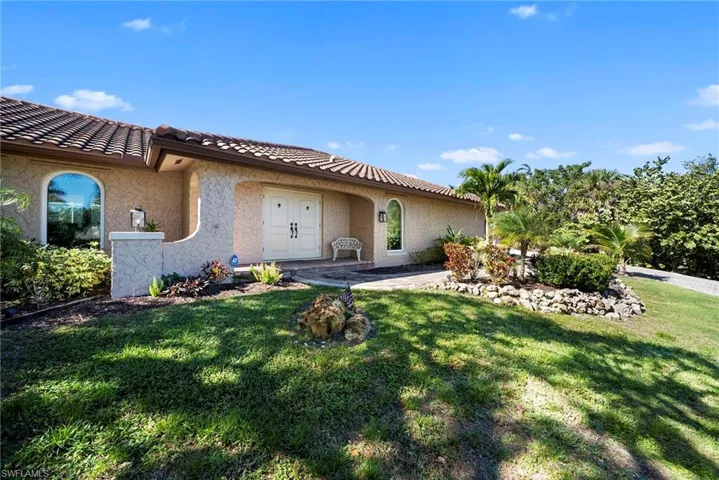 View of front of house featuring stucco siding, double front doors, and a tiled roof