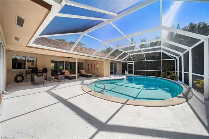 Outdoor pool featuring an outdoor hangout area, a lanai and bartop outside of kitchen window for direct service