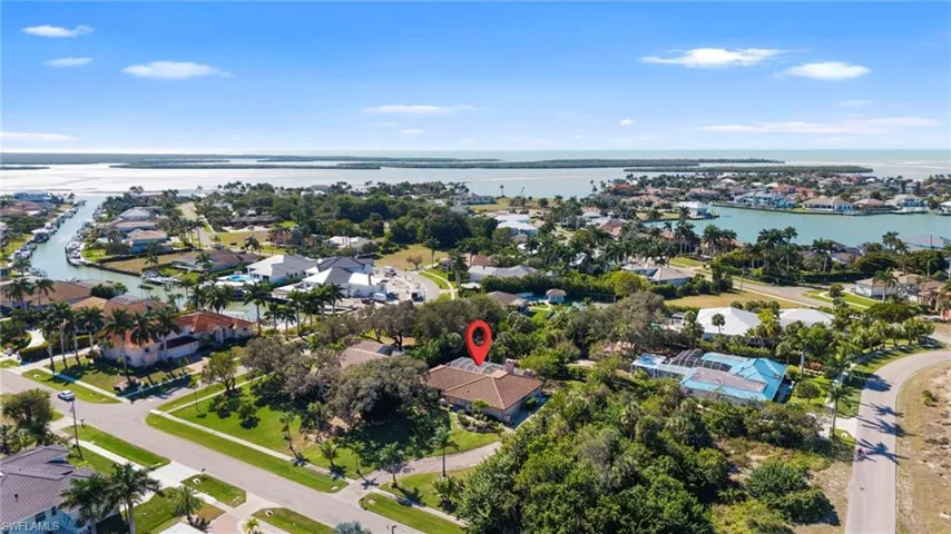 Aerial view of property and surrounding area featuring nearby suburban area and a nearby body of water