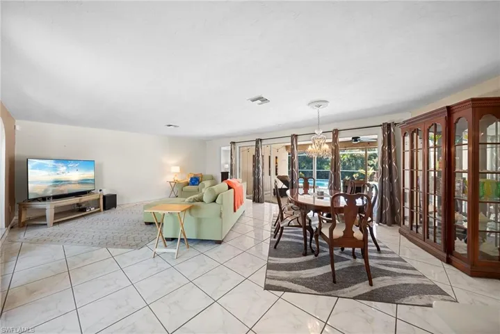 Dining space featuring a chandelier and light marble finish floors