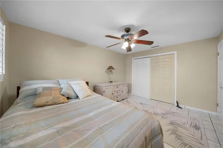 Bedroom featuring a closet and a ceiling fan. Tile floors throughout. No carpeting!