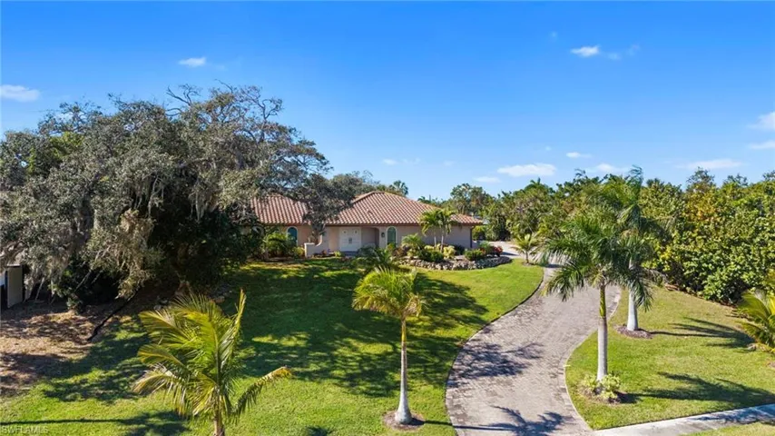 View of property at the top of the hill, the front yard and paver block driveway