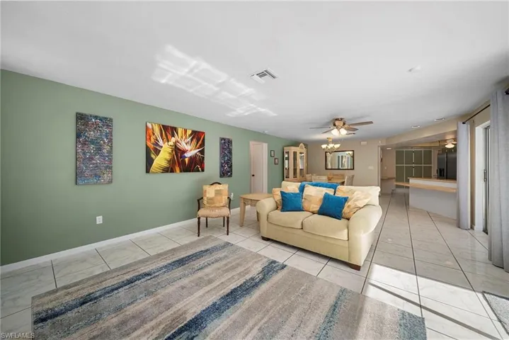 Generous living room featuring ceiling fan and tile flooring