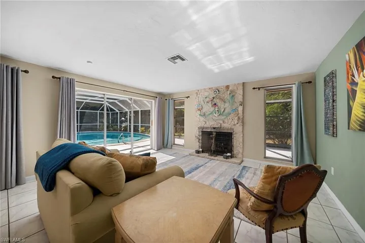 Living room with a fireplace and direct access to your beautiful southwestern exposure in ground pool