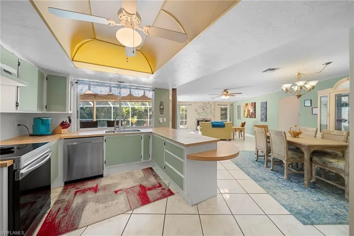 Kitchen featuring a peninsula, a ceiling fan, light countertops, appliances with stainless steel finishes, and green cabinets