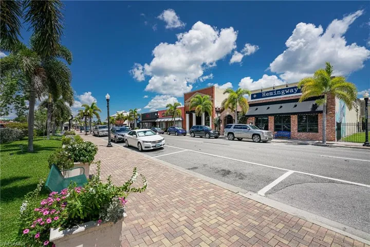 View of asphalt road with street lights, sidewalks, and curbs