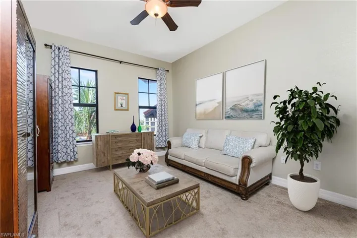 Living room featuring light colored carpet and ceiling fan