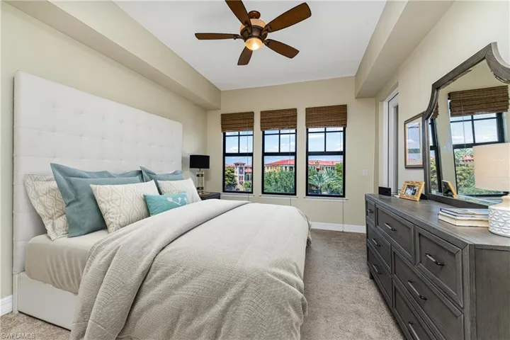Bedroom with light colored carpet and a ceiling fan