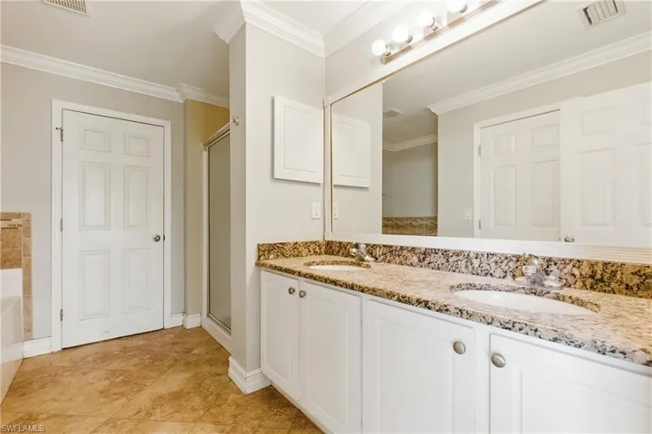Full bath featuring visible vents, a sink, crown molding, and double vanity