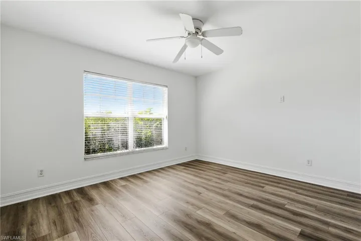 Unfurnished room featuring baseboards, ceiling fan, and wood finished floors