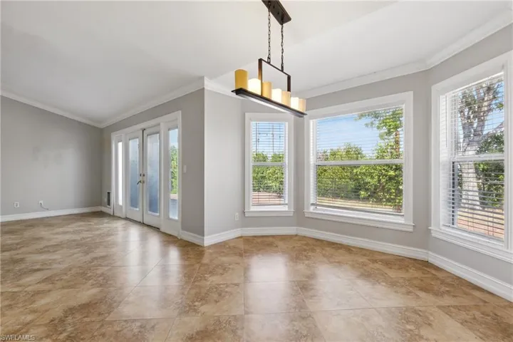Unfurnished dining area with crown molding, baseboards, and french doors