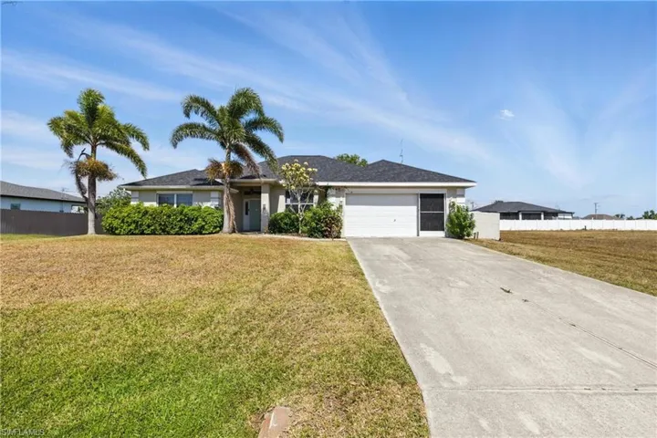 Single story home featuring a garage, fence, concrete driveway, and a front lawn