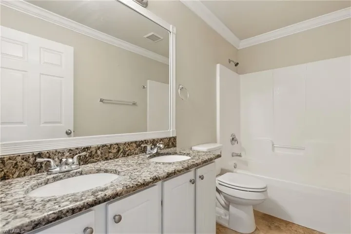 Full bath with crown molding, a sink, visible vents, and toilet