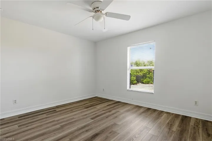 Empty room with baseboards, a ceiling fan, and wood finished floors
