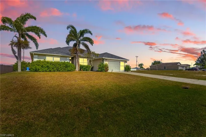 Single story home with a garage, driveway, and a front yard