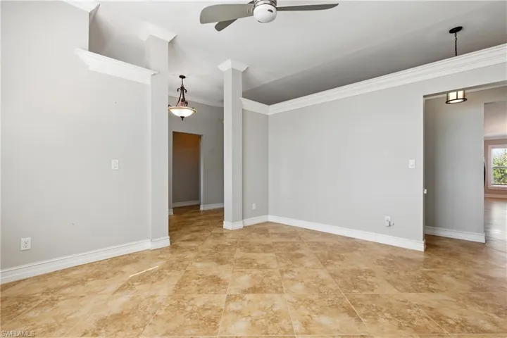 Empty room featuring a ceiling fan, baseboards, and ornamental molding