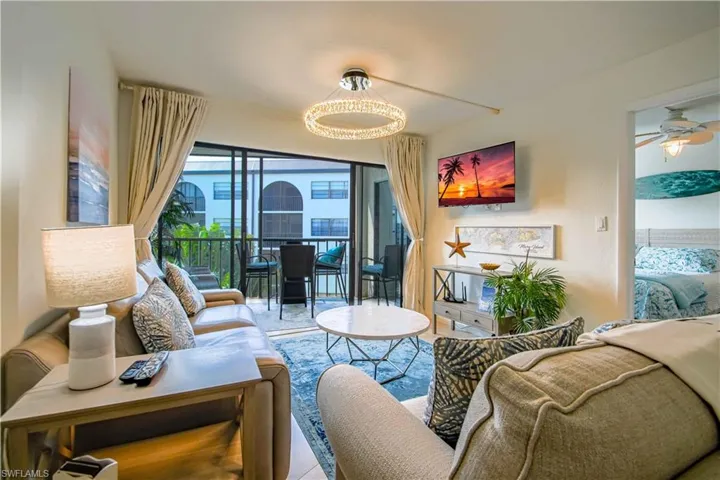 Living room with ceiling fan with notable chandelier