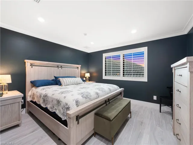 Bedroom with crown molding, light wood finished floors, and recessed lighting