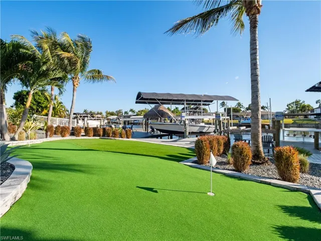 Surrounding community featuring a putting green, boat lift, a water view, and a boat dock