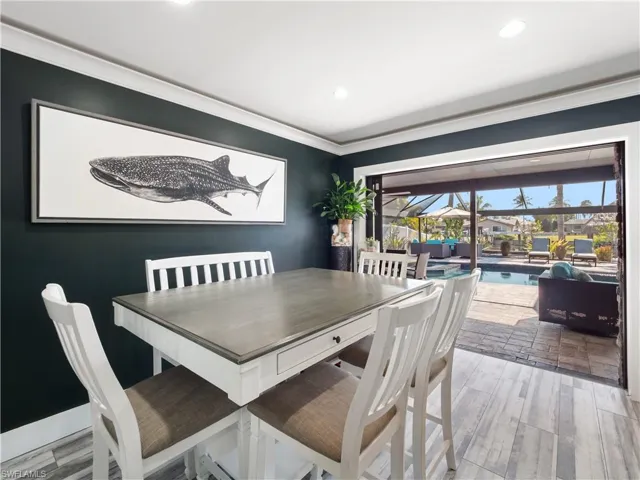 Dining room featuring a sunroom, light wood-style flooring, recessed lighting, and ornamental molding