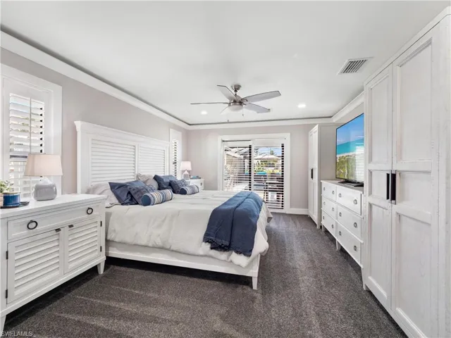 Bedroom featuring dark colored carpet, a ceiling fan, ornamental molding, access to exterior, and recessed lighting