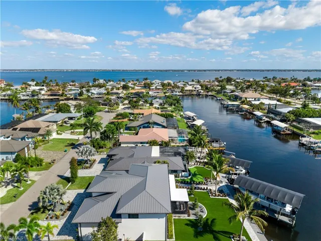 Aerial perspective of suburban area featuring a nearby body of water