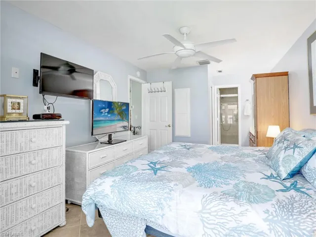 Bedroom with ceiling fan, visible vents, and light tile patterned flooring
