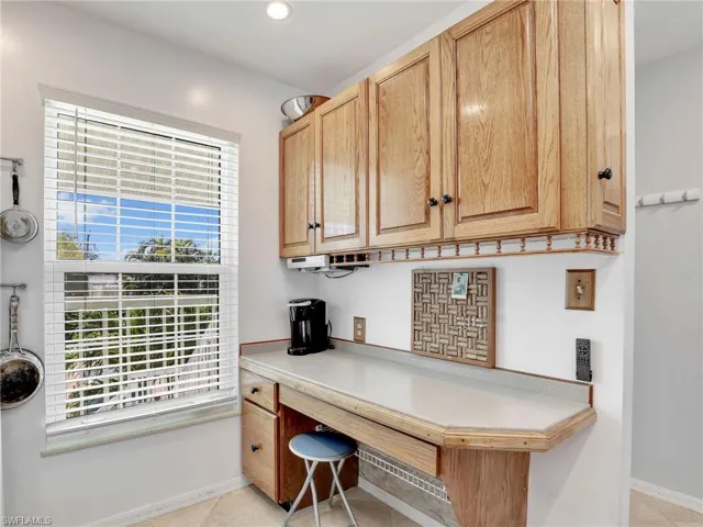 Office space featuring plenty of natural light, baseboards, light tile patterned floors, and built in study area
