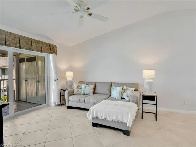 Living room featuring light tile patterned flooring, a ceiling fan, and baseboards
