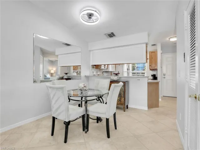 Dining room with light tile patterned floors, visible vents, and baseboards