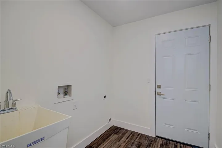 Laundry area featuring electric dryer hookup, dark wood finished floors, baseboards, and washer hookup