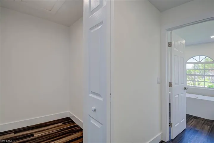 Hallway featuring dark wood-type flooring and baseboards