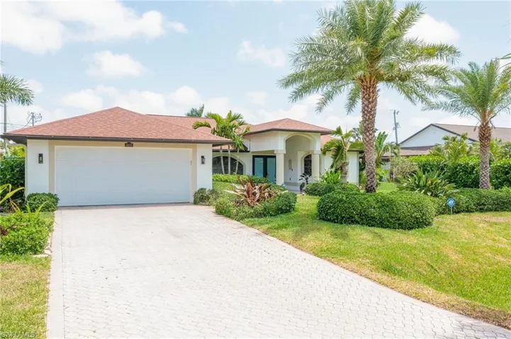 Mediterranean / spanish home featuring stucco siding, decorative driveway, a front yard, and an attached garage