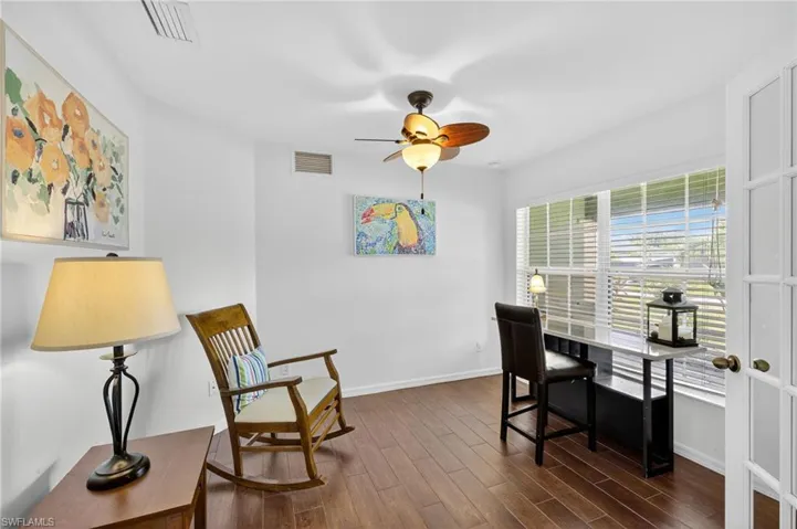Versatile den or home office with dark wood-style flooring and ceiling fan — ideal as a 4th bedroom, study, or flex space in this Cape Coral 3+Den home.