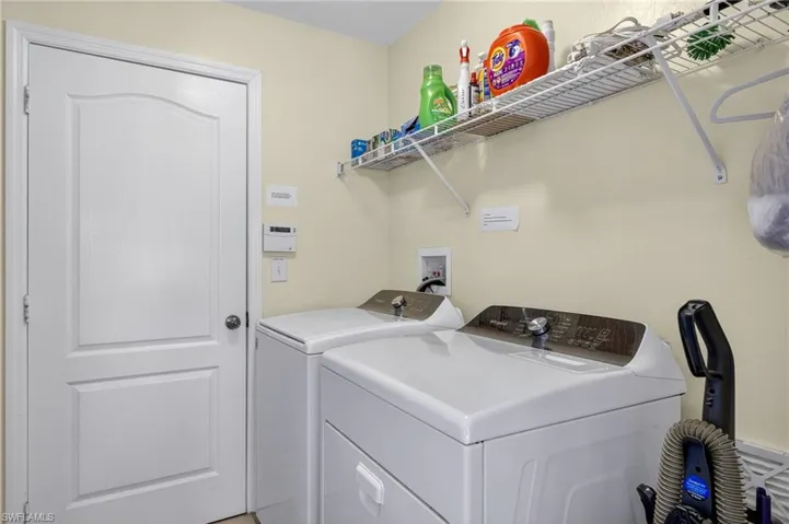 Dedicated indoor laundry room with full-size washer and dryer included — a premium convenience feature in this turnkey Cape Coral pool home.
