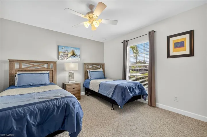 Bright bedroom with light-colored carpet and ceiling fan — one of multiple guest bedrooms in this spacious 3+Den Cape Coral single-family home.