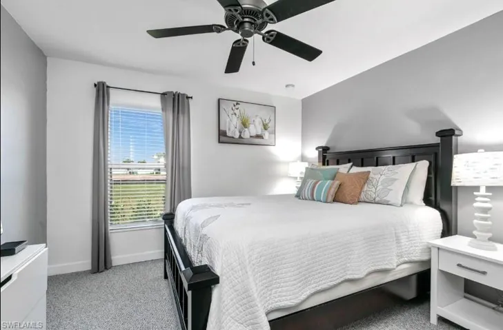 Guest bedroom with soft carpet flooring and ceiling fan — one of multiple well-appointed bedrooms in this spacious Cape Coral 3+Den pool home.