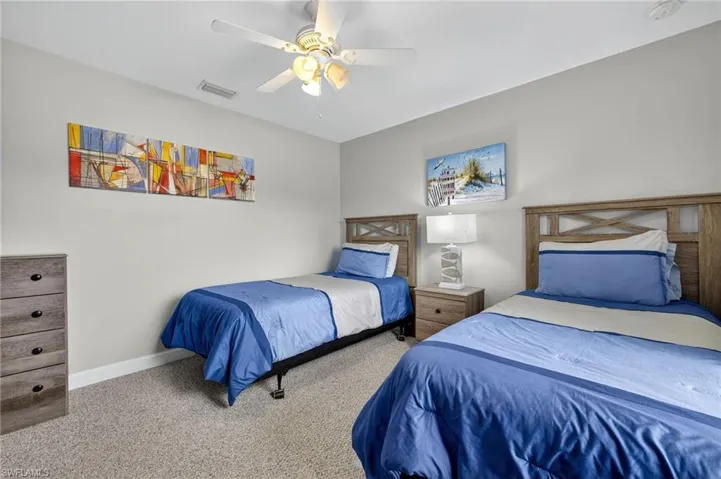 Cozy bedroom with carpet flooring and ceiling fan — move-in ready and fully furnished as part of this Cape Coral turnkey pool home.