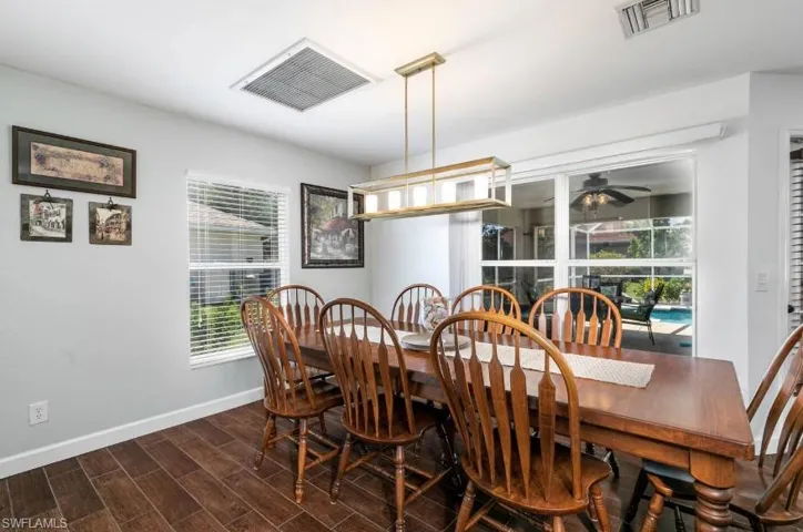 Open dining room with dark wood-style flooring and ceiling fan — naturally lit and ideally positioned adjacent to the kitchen and living areas.