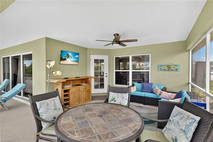Expansive screened lanai with outdoor dining area, lounge seating, and ceiling fan — your private outdoor oasis for year-round entertaining in Cape Coral, FL.