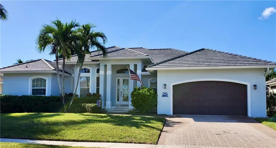 View of front of house with a garage and a front lawn