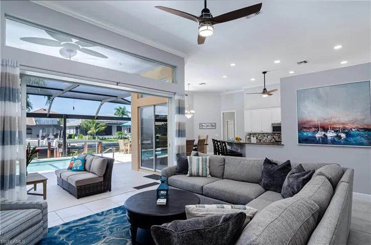 Tiled living room with crown molding and ceiling fan