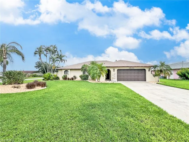 Ranch-style home featuring a garage and a front yard