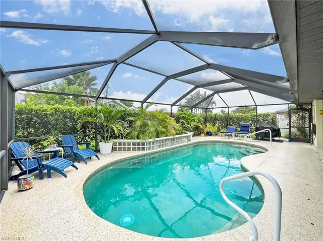 View of pool featuring glass enclosure and a patio area
