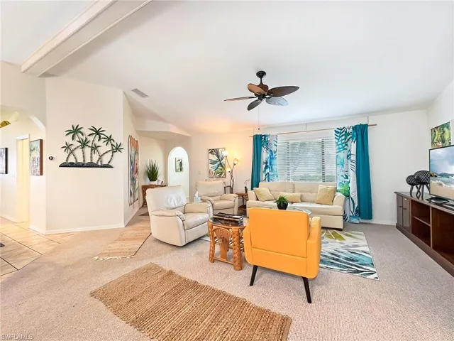 Living room featuring ceiling fan and light carpet